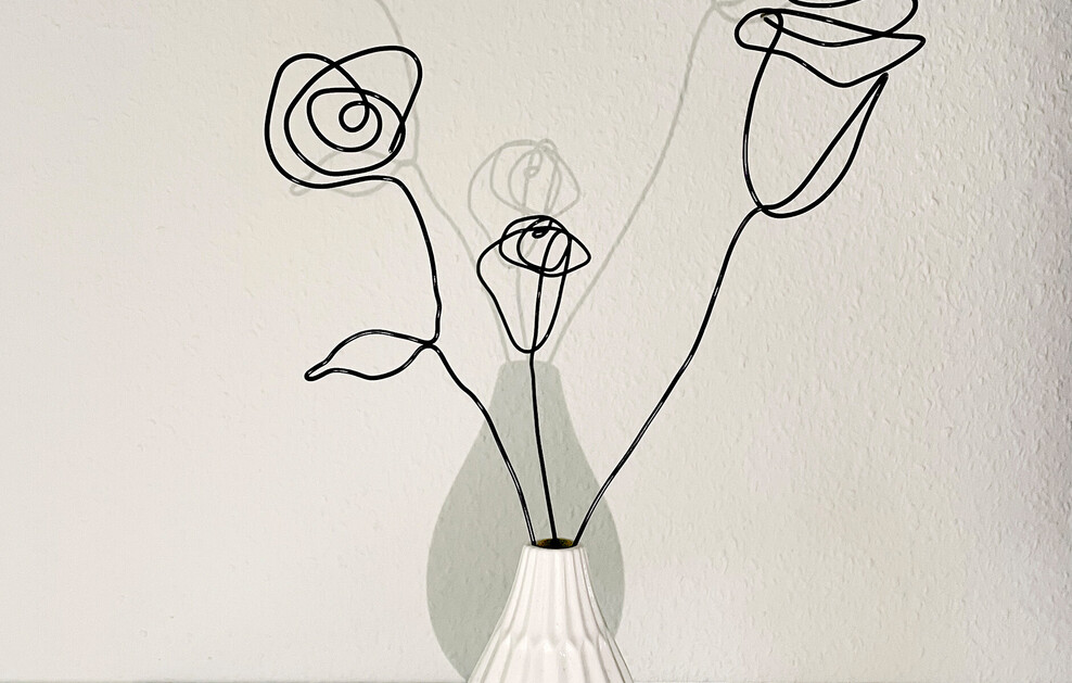 Rosen aus Draht in einer weißen Vase.